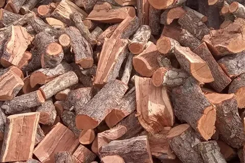 Leña de encina partida, de madera rojiza y corteza oscura